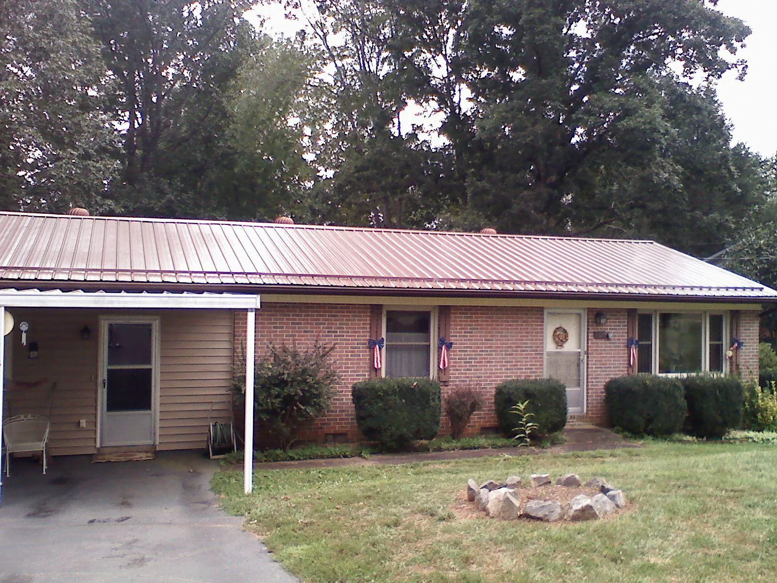 Bronze metal roof and carport on a brick ranch home — Roof Repair work by our crew in Sandy Spring